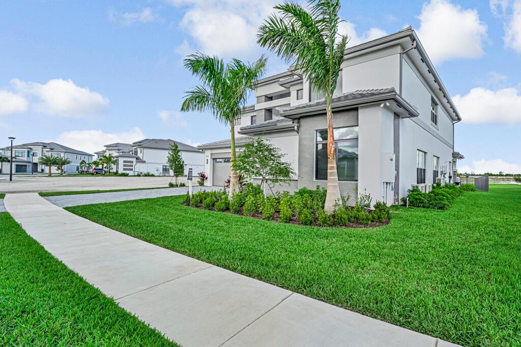 A two-story house with a gray exterior, palm trees, and a concrete walkway — 13531 Nesting Pines Way, Palm Beach Gardens FL 33412, PALM BEACH GARDENS, FL