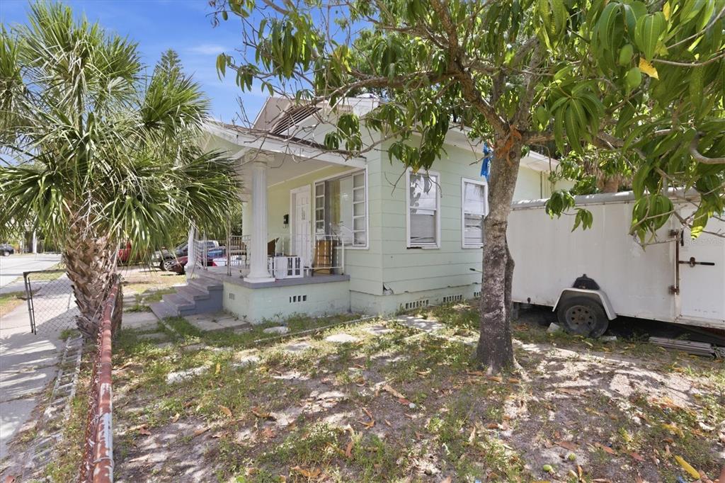 A light green house with a front porch and a trailer parked in the yard — 301 N 26TH STREET UNIT A, TAMPA, FL
