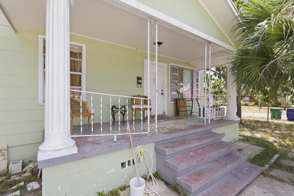 A light green house features a front porch with white columns, railings, and concrete steps — 301 N 26TH STREET UNIT A, TAMPA, FL