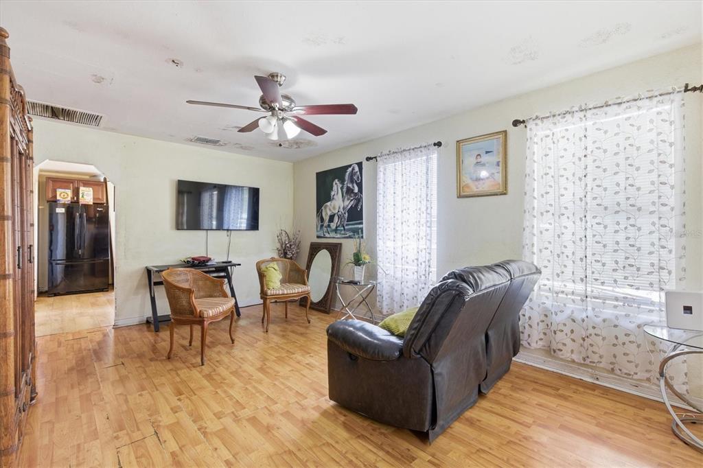 A living room features wood flooring, a ceiling fan, a television, and a leather sofa — 301 N 26TH STREET UNIT A, TAMPA, FL