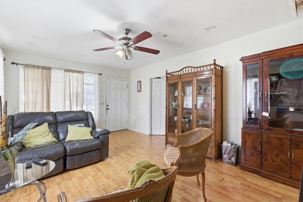 A living room features a leather sofa, two wooden chairs, and a large display cabinet — 301 N 26TH STREET UNIT A, TAMPA, FL