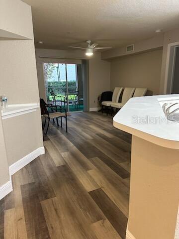 A living area with wood-look flooring, a ceiling fan, and a sliding door to a patio — 824 CAMARGO WAY UNIT 106, ALTAMONTE SPRINGS, FL
