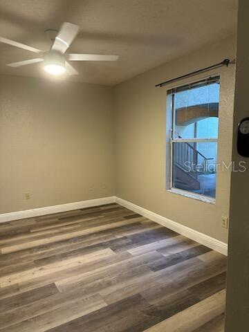 An empty room features light-colored walls, wood-look flooring, a ceiling fan, and a window — 824 CAMARGO WAY UNIT 106, ALTAMONTE SPRINGS, FL