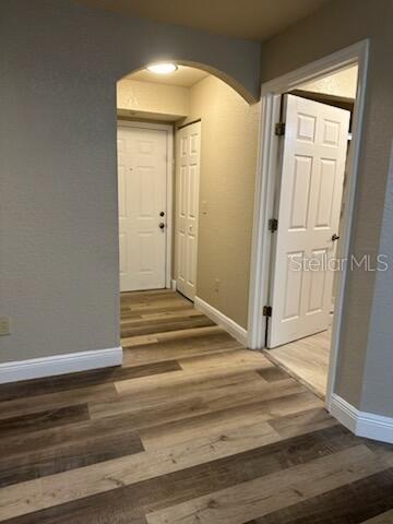 An interior view shows a hallway with wood-look flooring, an arched entryway, and white doors — 824 CAMARGO WAY UNIT 106, ALTAMONTE SPRINGS, FL