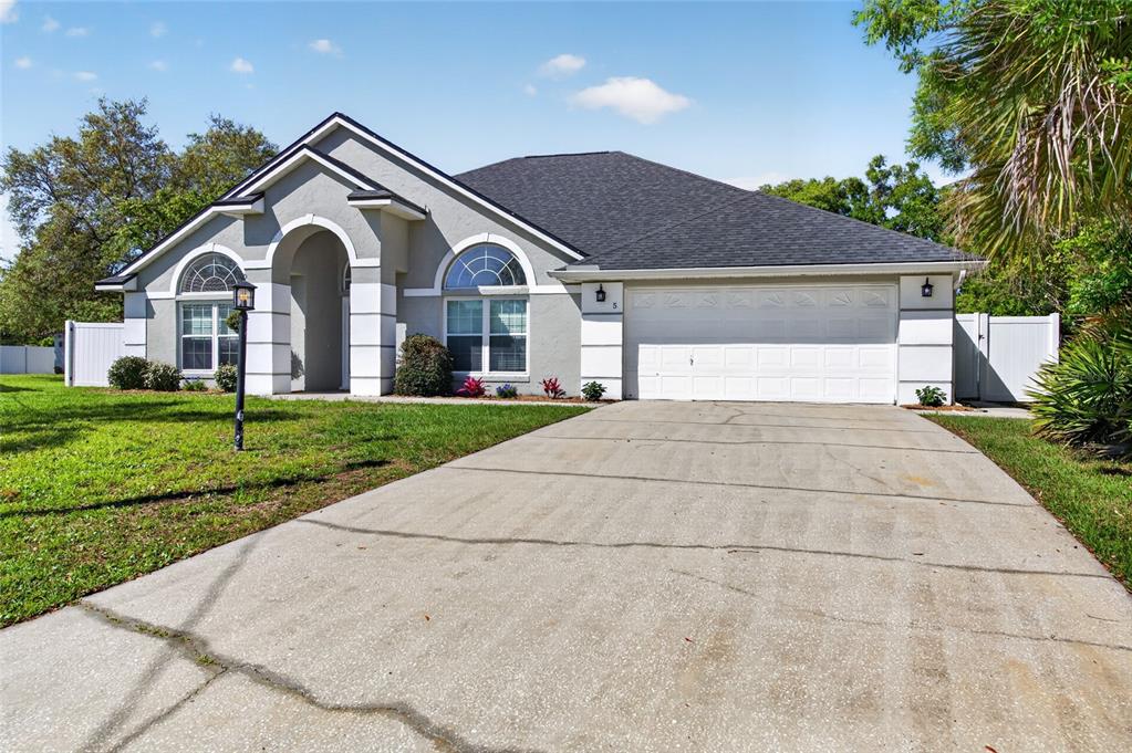 A single-story house with a gray stucco exterior, white trim, and a two-car garage — 5 FARR PLACE, PALM COAST, FL