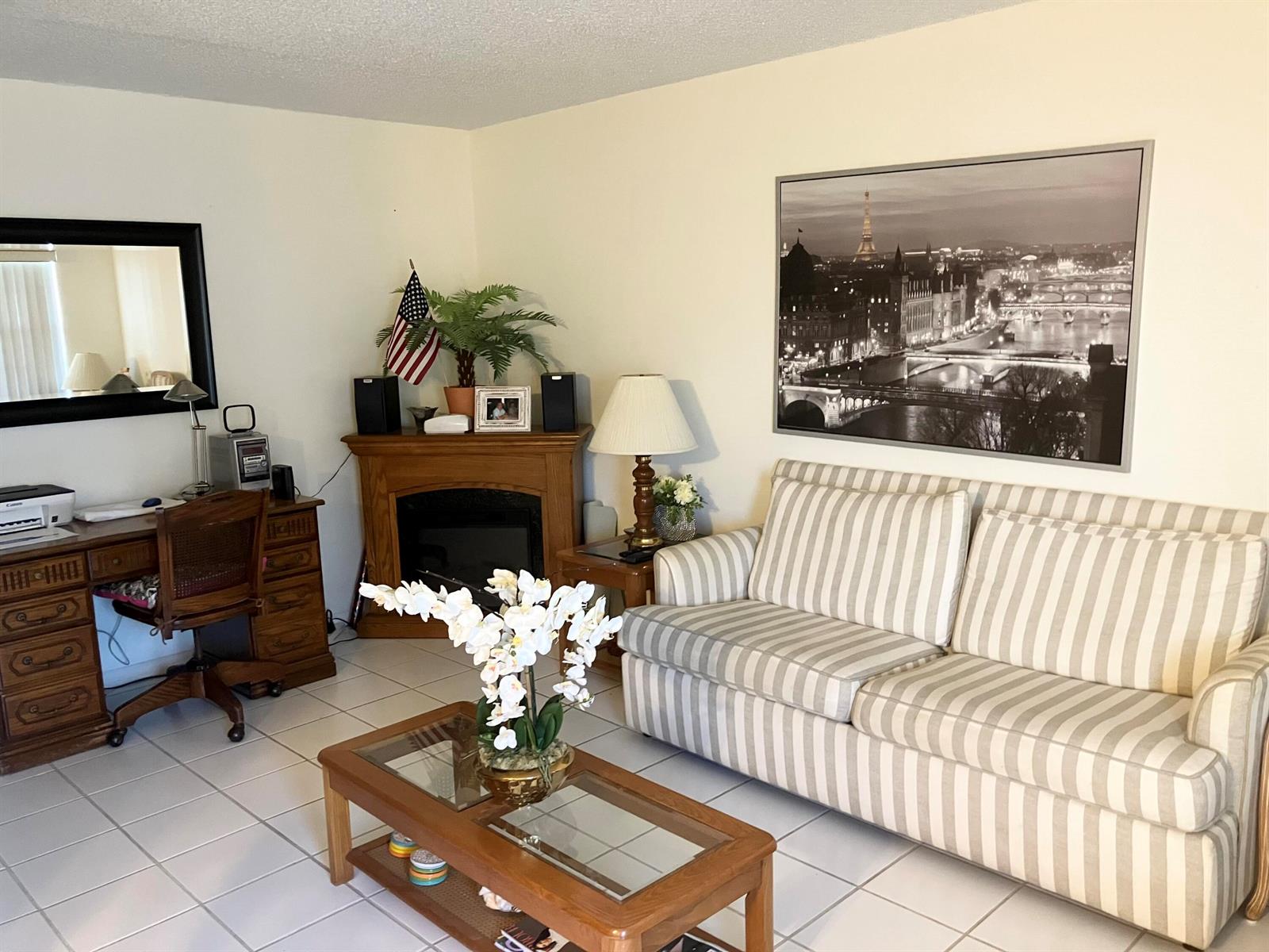 A living room features a striped sofa, a wooden coffee table, a fireplace, and a desk — 283 Durham H # 283, Deerfield Beach FL 33442, DEERFIELD BEACH, FL
