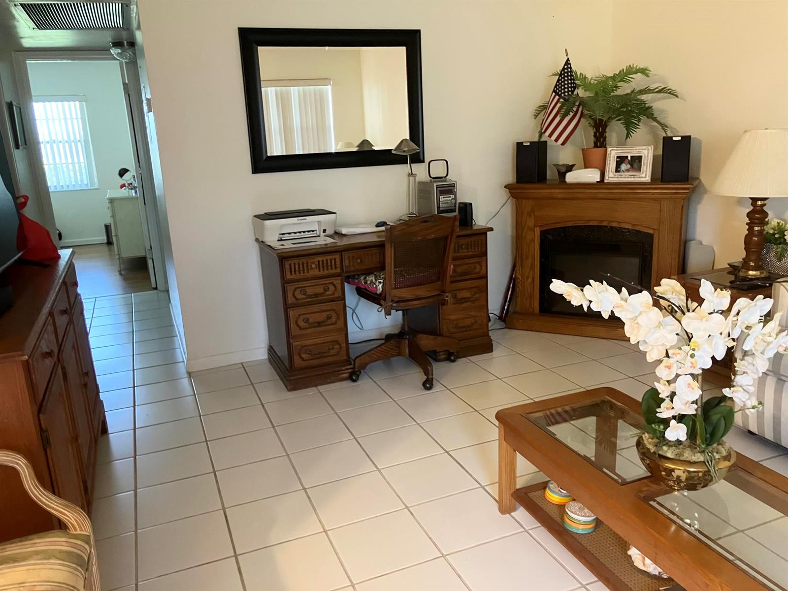 A living room with a wooden desk, fireplace, tile flooring, and a coffee table — 283 Durham H # 283, Deerfield Beach FL 33442, DEERFIELD BEACH, FL