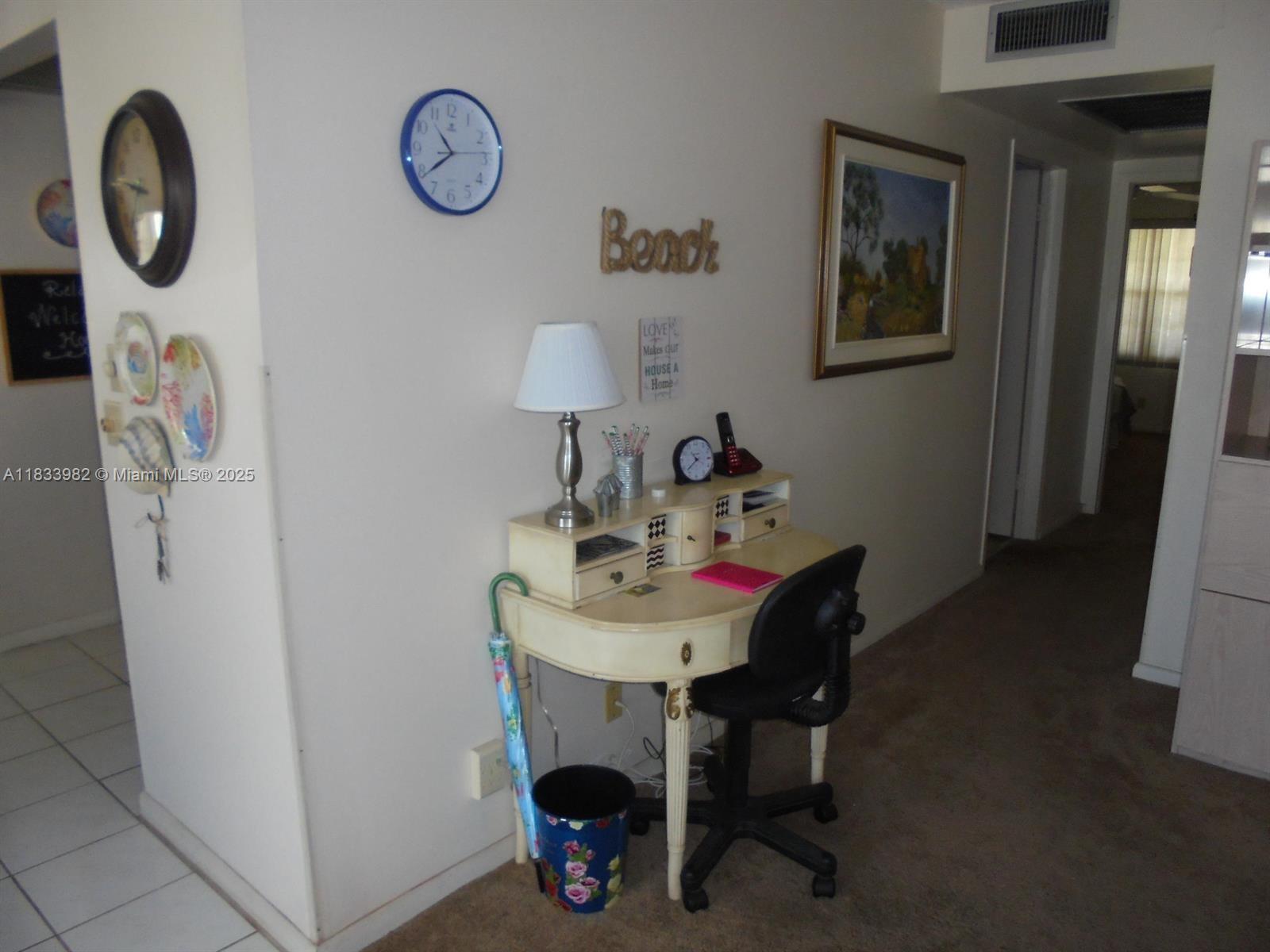 A small desk with a chair and lamp sits against a wall in a hallway — 31 Fanshaw A # 31A, Boca Raton FL 33434, BOCA RATON, FL
