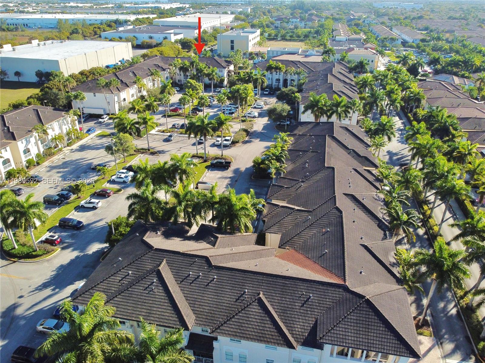 An aerial view shows a multi-story residential complex with dark tile roofs and palm trees — 11403 NW 89th St # 219, Doral FL 33178, DORAL, FL