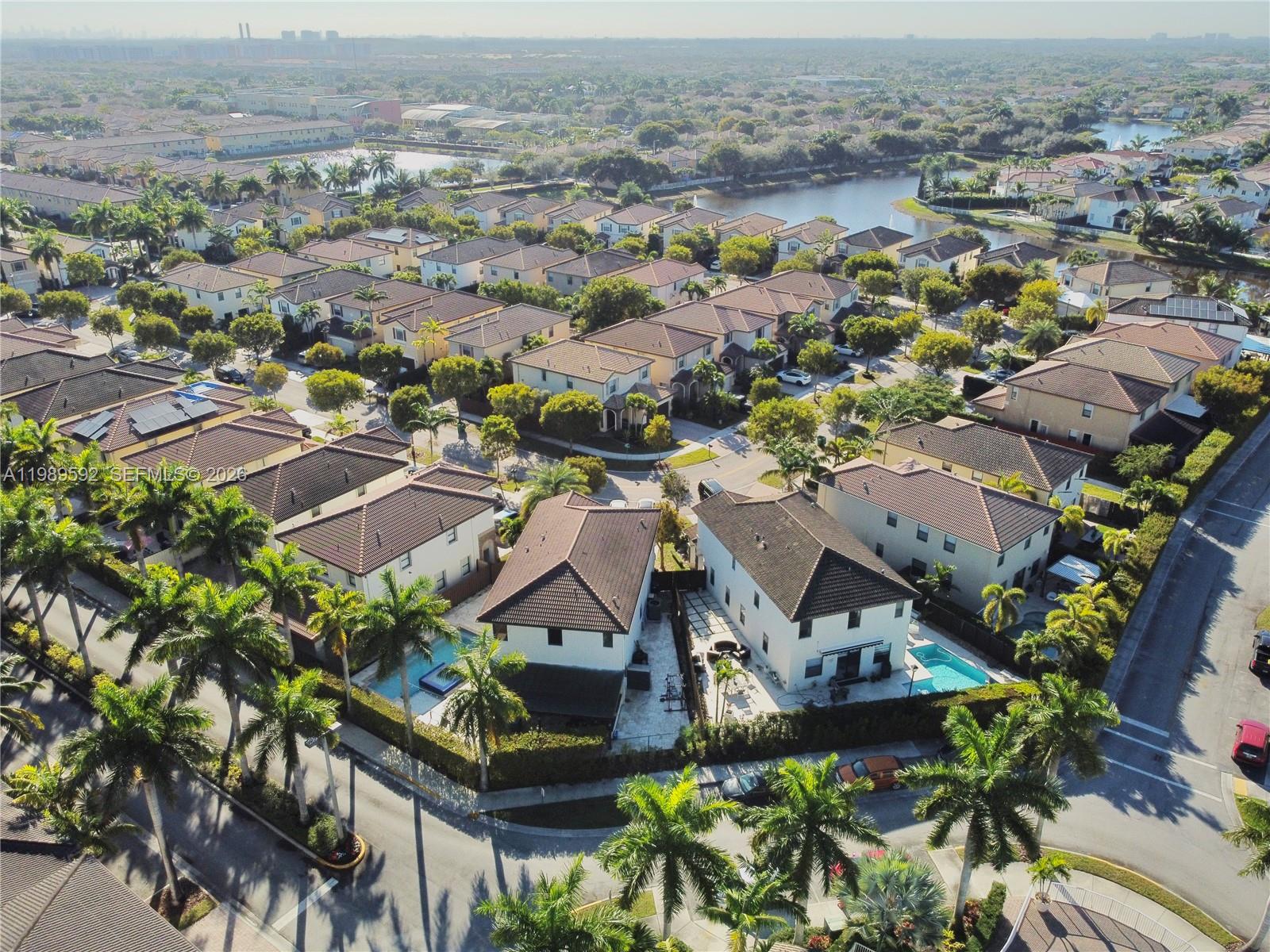 An aerial view shows a suburban neighborhood with houses, swimming pools, and palm trees — 11403 NW 89th St # 219, Doral FL 33178, DORAL, FL