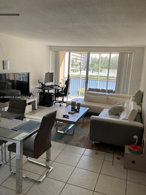 A living room with a white sectional sofa, dining area, and a balcony overlooking water — 1770 NE 191st St # 1, Miami FL 33179, MIAMI, FL
