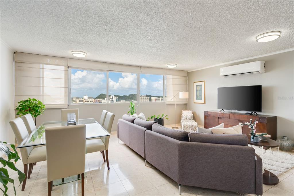 A living and dining area with tile floors, a gray sectional, and large windows — 1704 SAN PATRICIO AVENUE UNIT 1704, GUAYNABO, PR