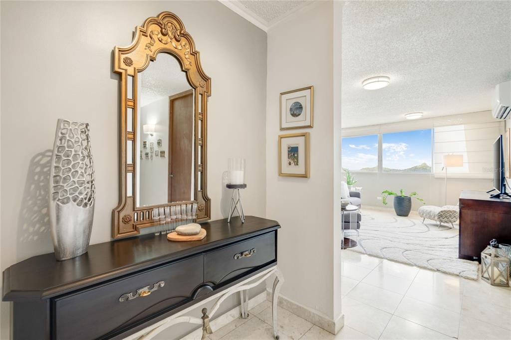 A dark wood console table with a gold mirror sits in a tiled entryway — 1704 SAN PATRICIO AVENUE UNIT 1704, GUAYNABO, PR