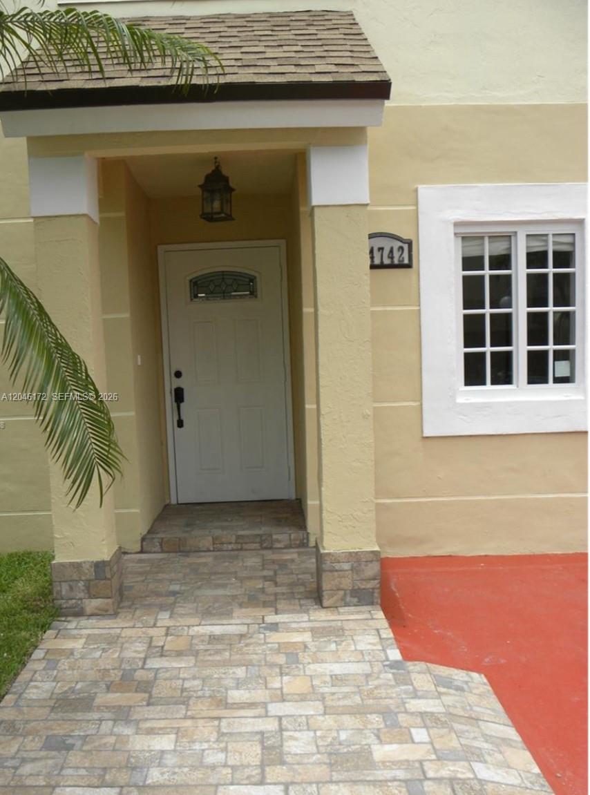The exterior of a home features a stone walkway leading to a covered front entrance — 14742 SW 92nd St Rd, Miami FL 33196, MIAMI, FL
