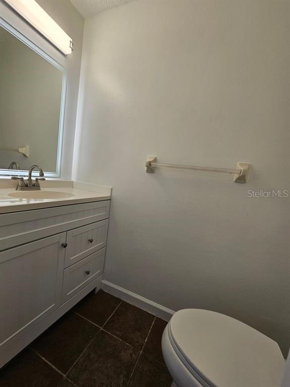A bathroom features a white vanity with a sink, a mirror, and a towel bar — 601 BAINBRIDGE DRIVE, BRANDON, FL