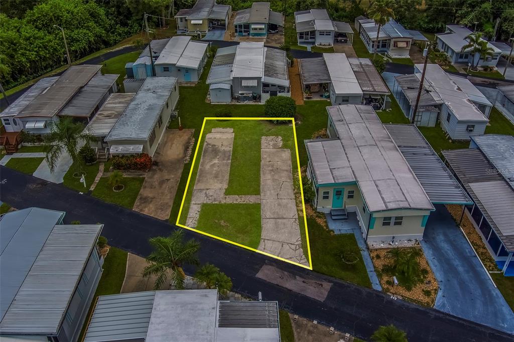 An aerial view shows a vacant residential lot with a concrete pad in a mobile home community — 16940 US HIGHWAY 19 N UNIT 244, CLEARWATER, FL