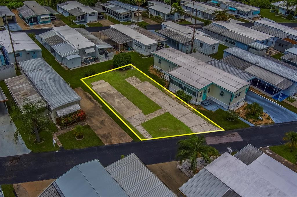 An aerial view shows a vacant residential lot with a concrete pad in a mobile home park — 16940 US HIGHWAY 19 N UNIT 244, CLEARWATER, FL