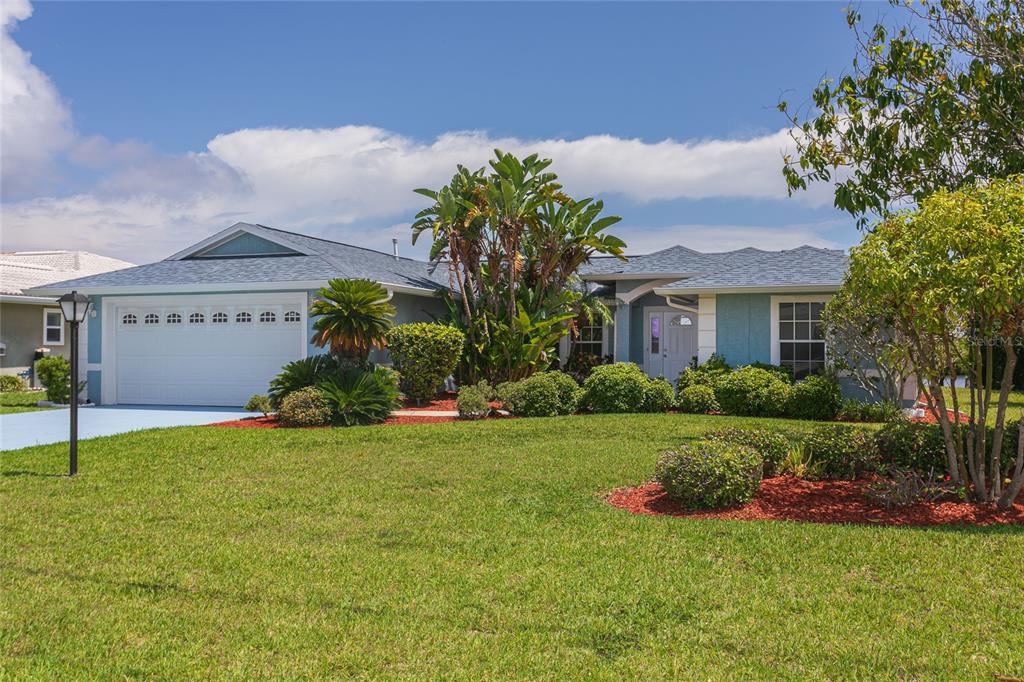 A screened-in pool and spa overlook a body of water from a concrete patio — 5557 BOWLINE BEND, NEW PORT RICHEY, FL