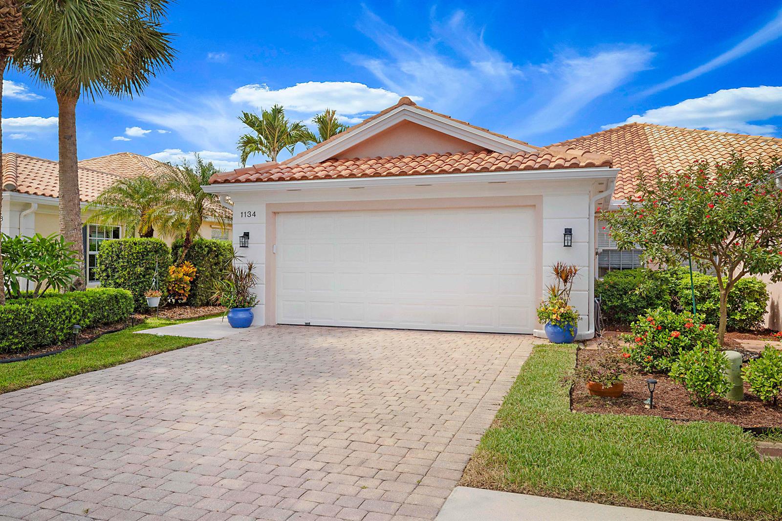 A single-story house with a white garage door, tile roof, and a paved driveway — 1134 SW Balmoral Trace, Stuart FL 34997, STUART, FL
