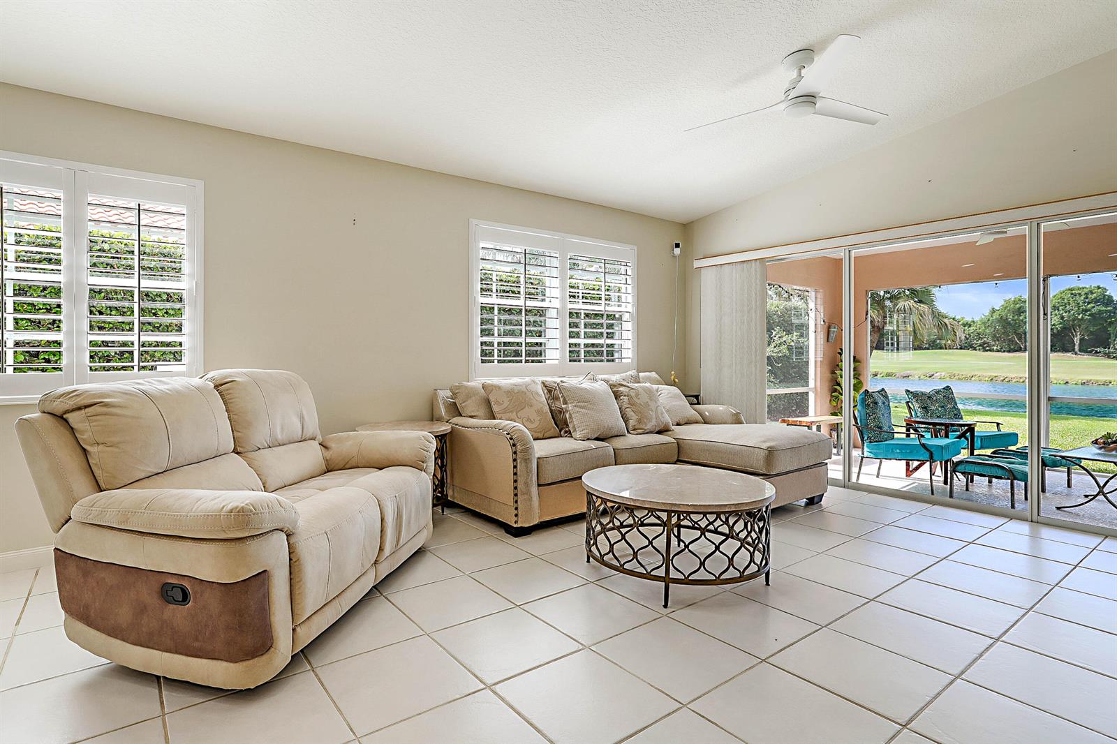 A living room features tile floors, a beige sectional, a recliner, and sliding glass doors — 1134 SW Balmoral Trace, Stuart FL 34997, STUART, FL