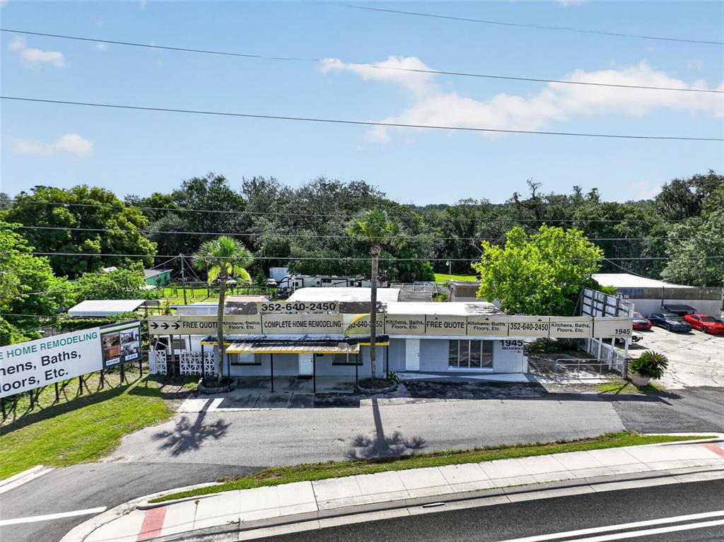An exterior view of a single-story commercial building with signage advertising home remodeling services — 1945 S US HIGHWAY 441, LADY LAKE, FL