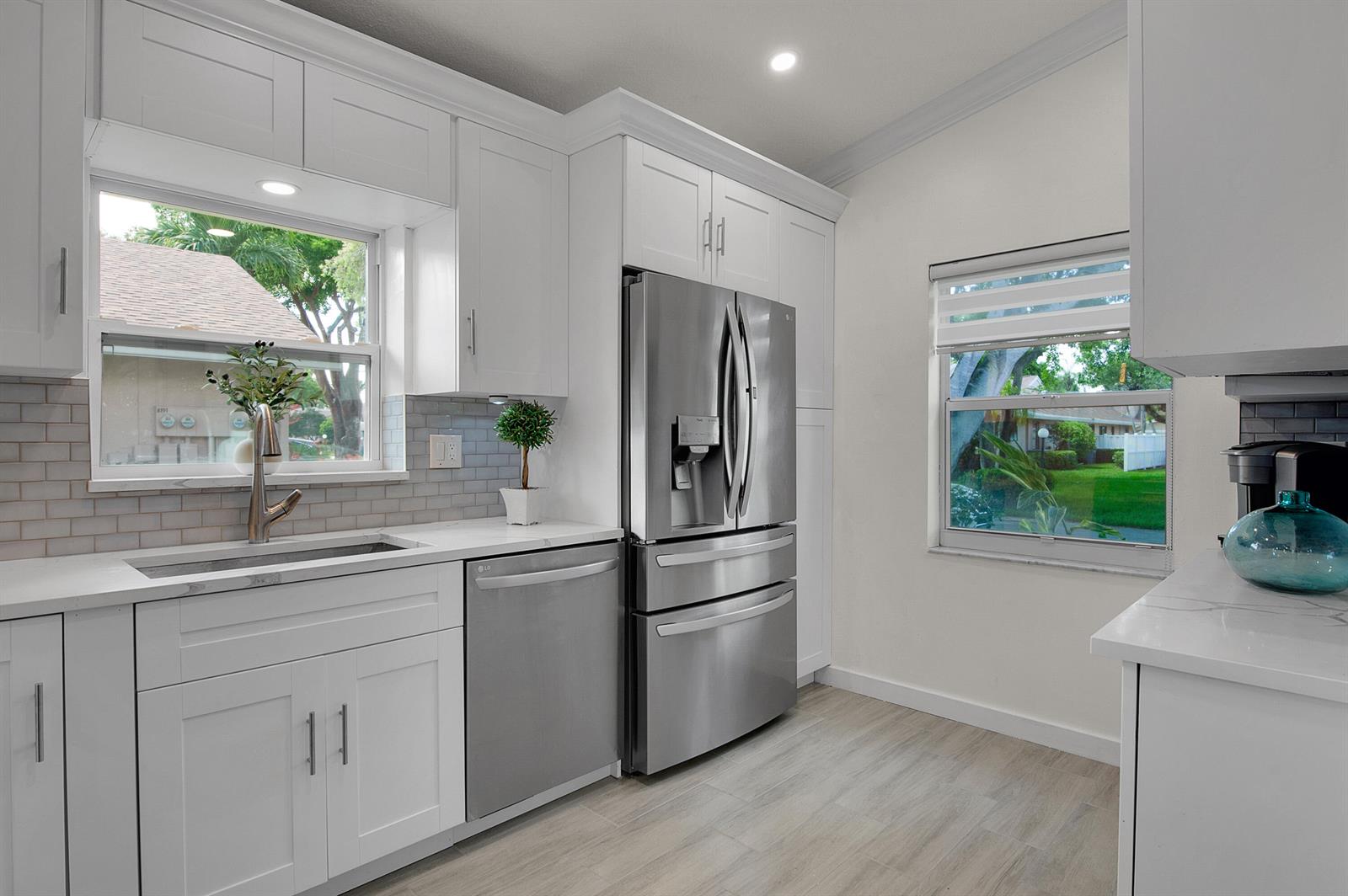 A kitchen with white cabinets, stainless steel appliances, a sink, and two windows — 8182 Springtree Road, Boca Raton FL 33496, BOCA RATON, FL