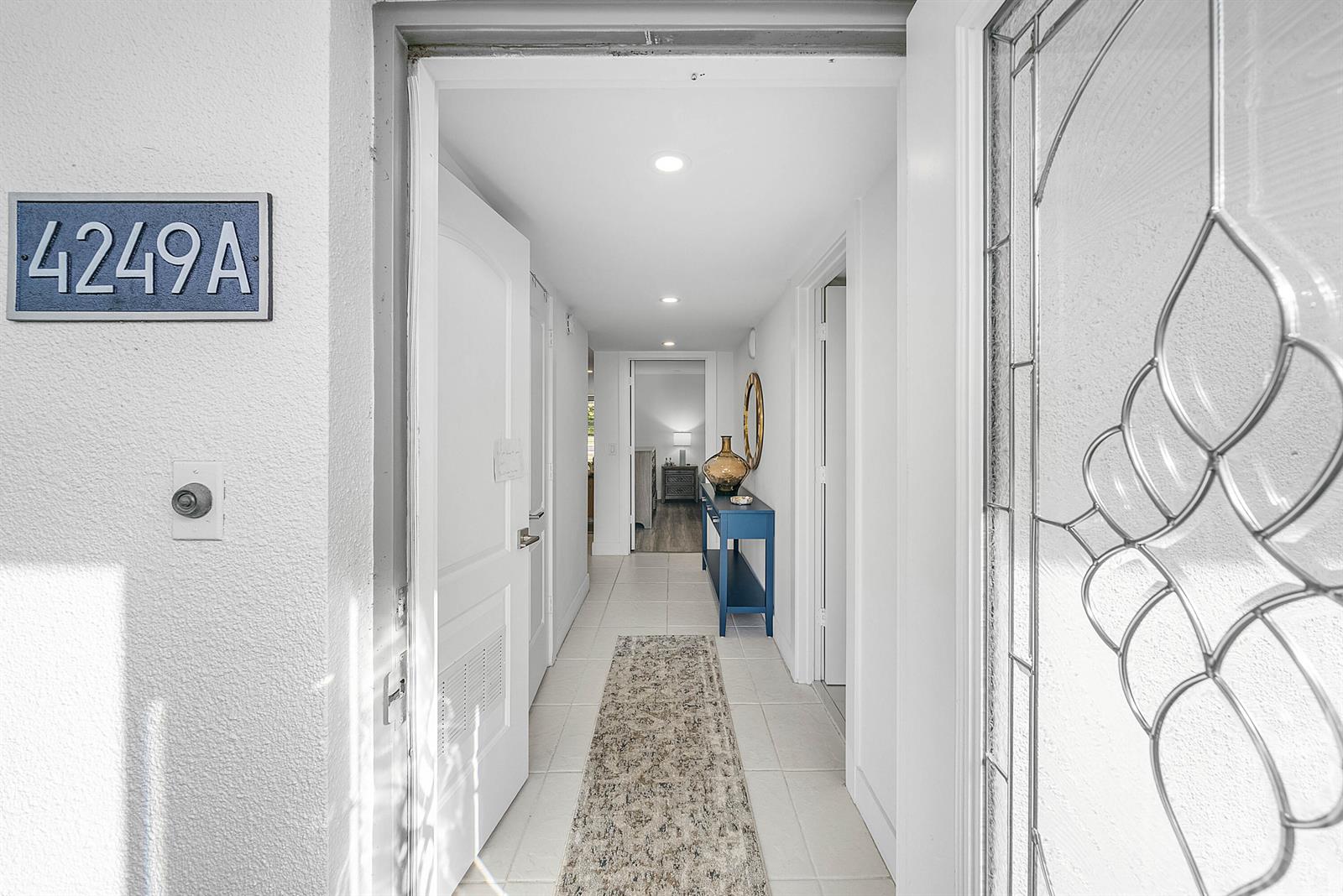 A view through an open front door into a tiled hallway with a blue console table — 4249 N Quail Ridge Dr Drive # A, Boynton Beach FL 33436, BOYNTON BEACH, FL
