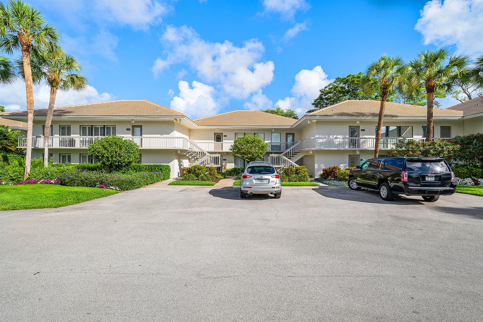 A two-story apartment building with a parking lot, palm trees, and two parked vehicles — 4249 N Quail Ridge Dr Drive # A, Boynton Beach FL 33436, BOYNTON BEACH, FL