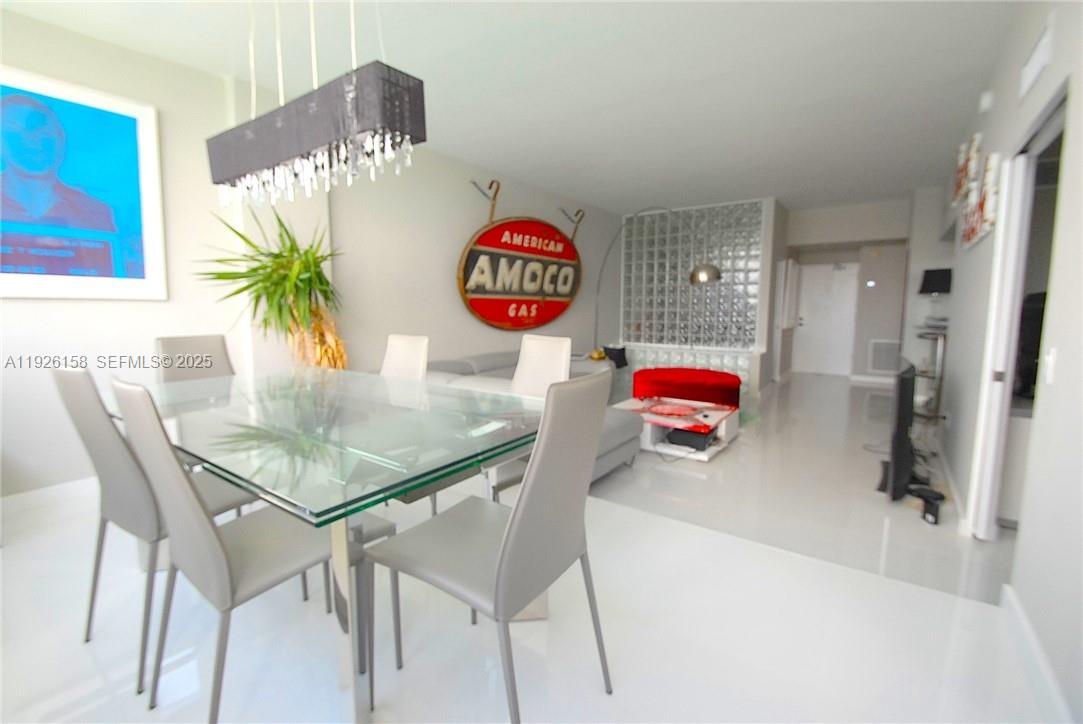 A dining area with a glass table and chairs sits adjacent to a living space — 800 West Ave, Miami Beach FL 33139, MIAMI BEACH, FL