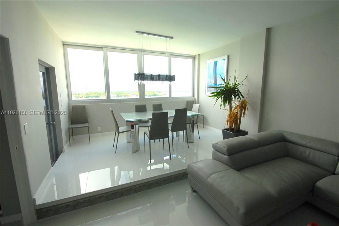 A dining area with a glass table and chairs sits on a raised platform — 800 West Ave, Miami Beach FL 33139, MIAMI BEACH, FL