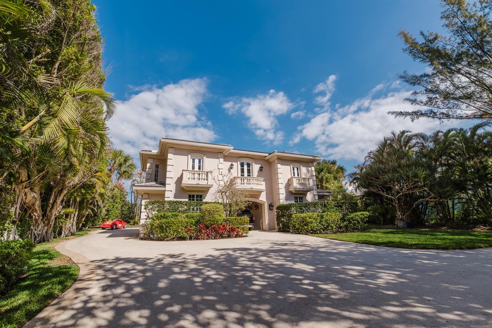 A two-story beige house with three balconies sits at the end of a paved driveway — 19 N Beach Road, Jupiter Island FL 33455, JUPITER ISLAND, FL
