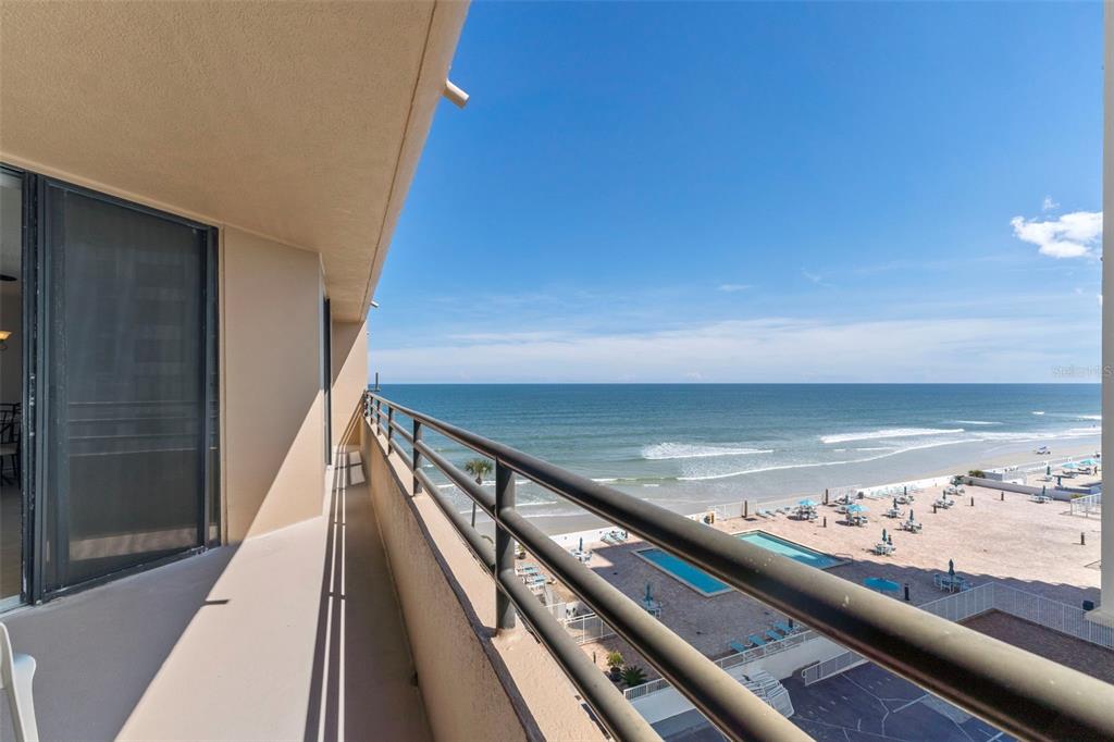 A balcony with a metal railing overlooks a beach, swimming pools, and the ocean — 3023 S ATLANTIC AVENUE UNIT 6060, DAYTONA BEACH, FL