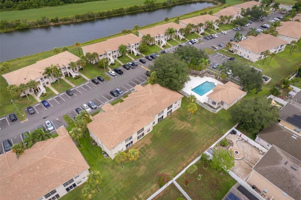 An aerial view shows multiple apartment buildings, a swimming pool, and a parking lot — 13403 FAIRWAY GLEN DRIVE UNIT 203, ORLANDO, FL