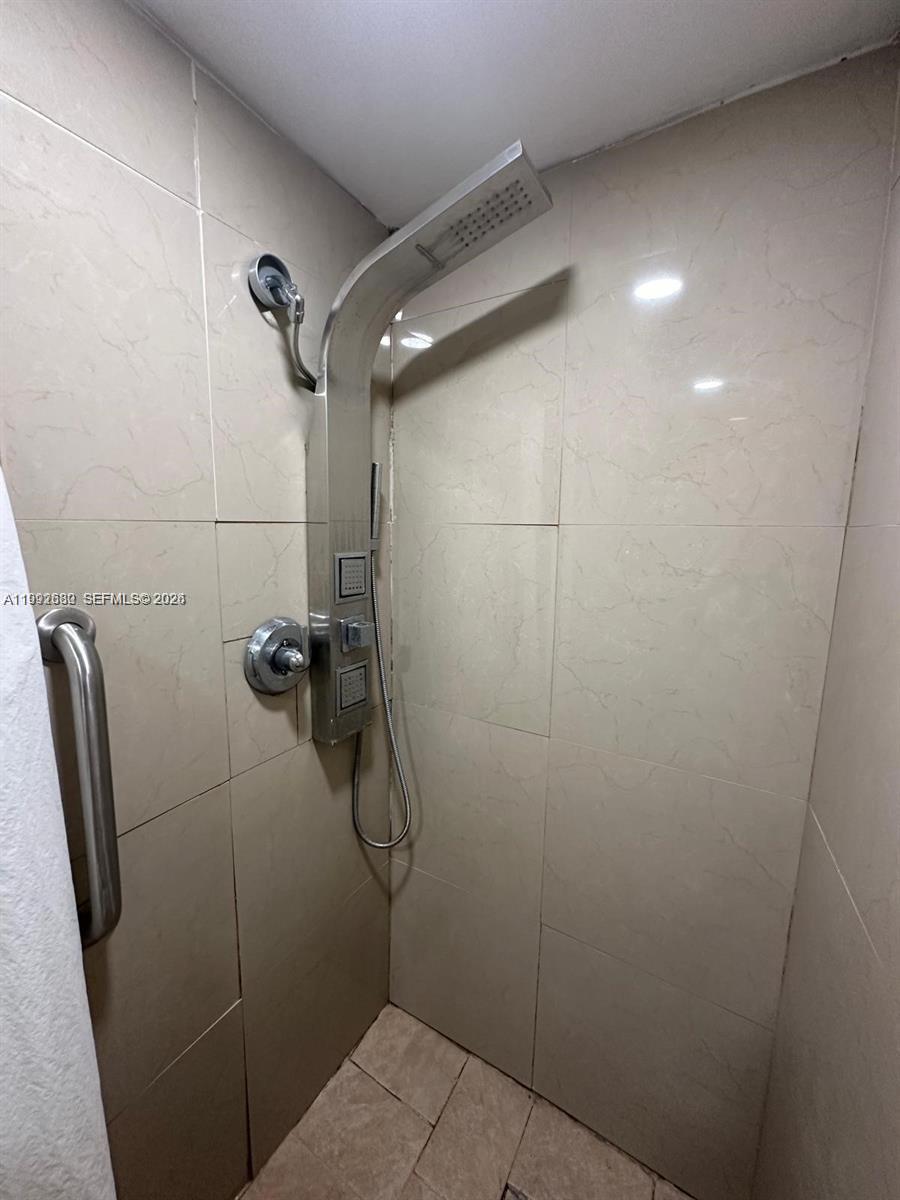 A shower stall features a stainless steel panel system with a rainfall showerhead and handle — 1572 NE 149th St # C, Miami FL 33161, MIAMI, FL