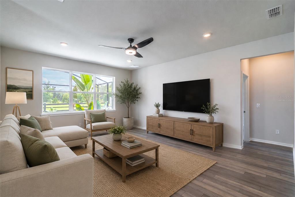 This living room features a sectional sofa, a wooden coffee table, and a wall-mounted television — 1681 BLOSSOM SOUND COURT, OVIEDO, FL