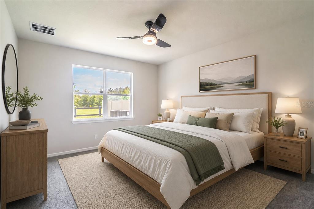 A bedroom features a bed with a green runner, wood furniture, and a ceiling fan — 1681 BLOSSOM SOUND COURT, OVIEDO, FL