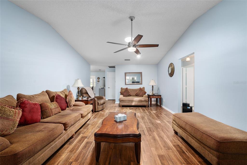 A living room features brown sofas, a wooden coffee table, and wood-look flooring — 9820 SW 89TH TERRACE UNIT E, OCALA, FL