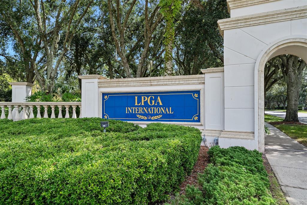 A white stone entrance monument with a blue sign reading LPGA International stands outdoors — 188 MENDOZA CIRCLE, DAYTONA BEACH, FL