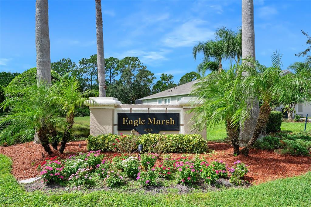 A stone monument sign reading Eagle Marsh stands in a landscaped garden with palm trees — 188 MENDOZA CIRCLE, DAYTONA BEACH, FL