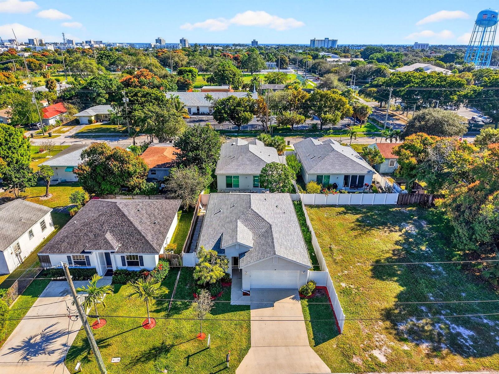 An aerial view shows suburban houses with gray roofs, driveways, and lawns in a neighborhood — 341 Oak Alley, Delray Beach FL 33444, DELRAY BEACH, FL