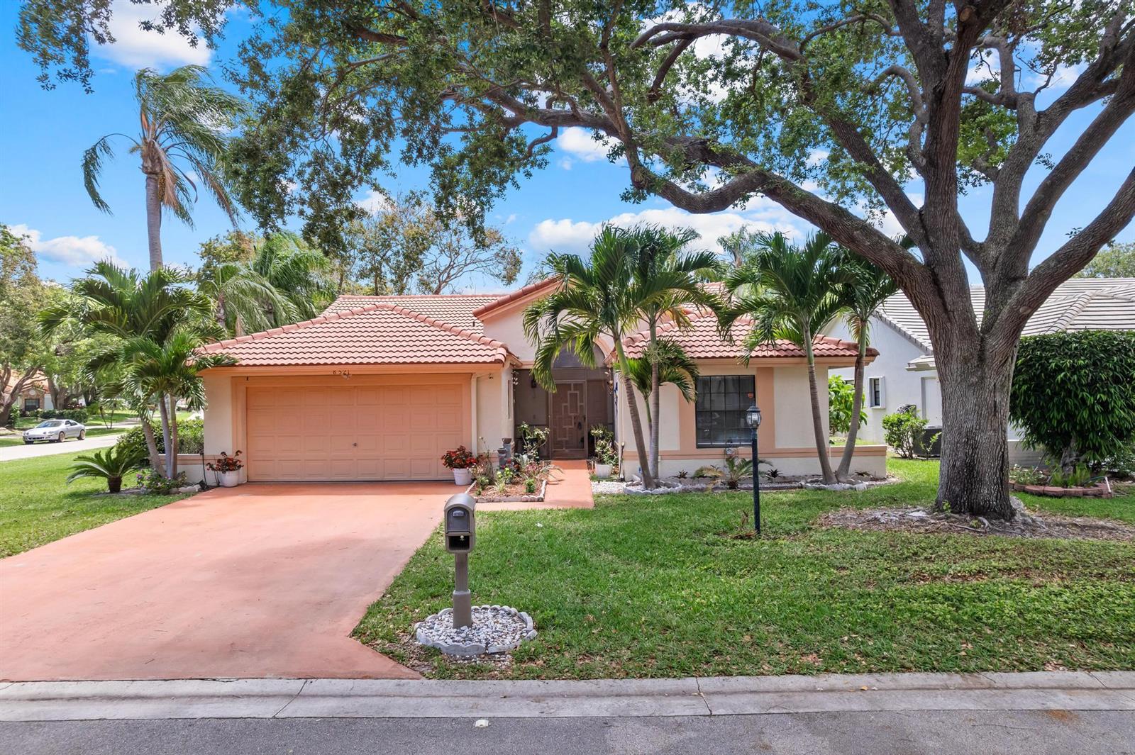 A single-story house with a tile roof, two-car garage, and palm trees in the front yard — 8521 Leeway Lane, Boynton Beach FL 33436, BOYNTON BEACH, FL
