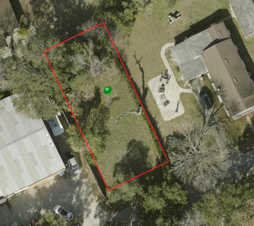 An aerial view shows a rectangular vacant lot outlined in red between two existing properties — 213 LINCOLN AVENUE, ORMOND BEACH, FL
