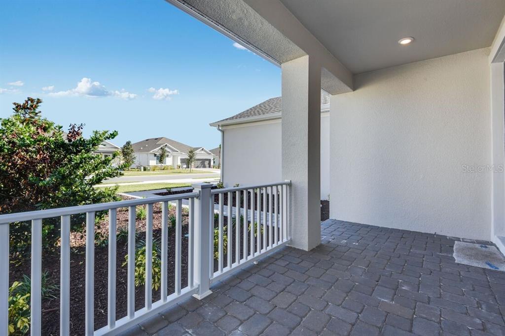 A modern kitchen features white cabinetry, a large island with a sink, and light wood flooring — 846 JUNONIA BOULEVARD, NEW SMYRNA BEACH, FL