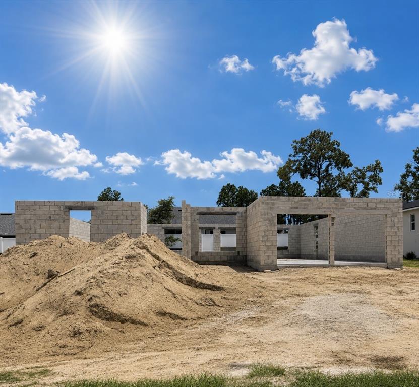 A construction site shows the concrete block walls of a house under a sunny sky — 8427 N INCA WAY, CITRUS SPRINGS, FL