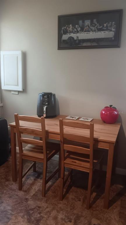 A dining area features a wooden table with two chairs, an air fryer, and wall art — 2693 CR 426F, LAKE PANASOFFKEE, FL