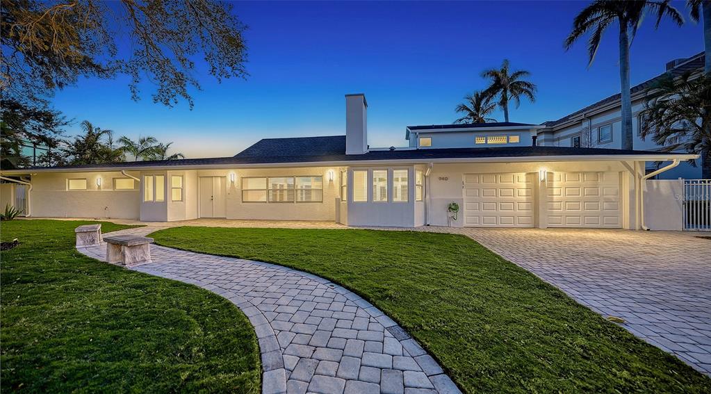 A single-story house with a white exterior, a paved walkway, and a two-car garage — 940 ALAMEDA WAY, SARASOTA, FL