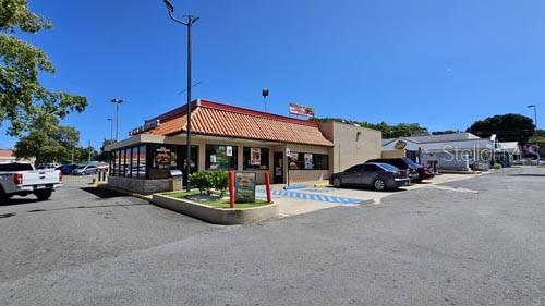 A commercial building with a tiled roof and parking lot under a clear blue sky — PR-194 INT EL CONQUISTADOR, FAJARDO, PR