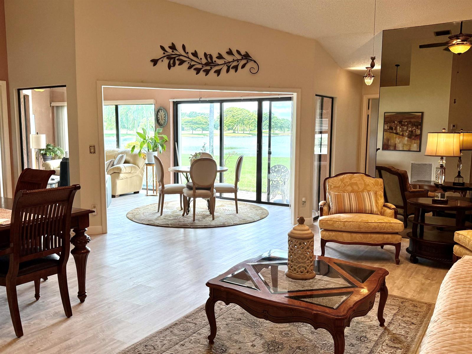 A living room with a coffee table, armchair, and a view of a lake outside — 5878 Parkwalk Circle W, Boynton Beach FL 33472, BOYNTON BEACH, FL
