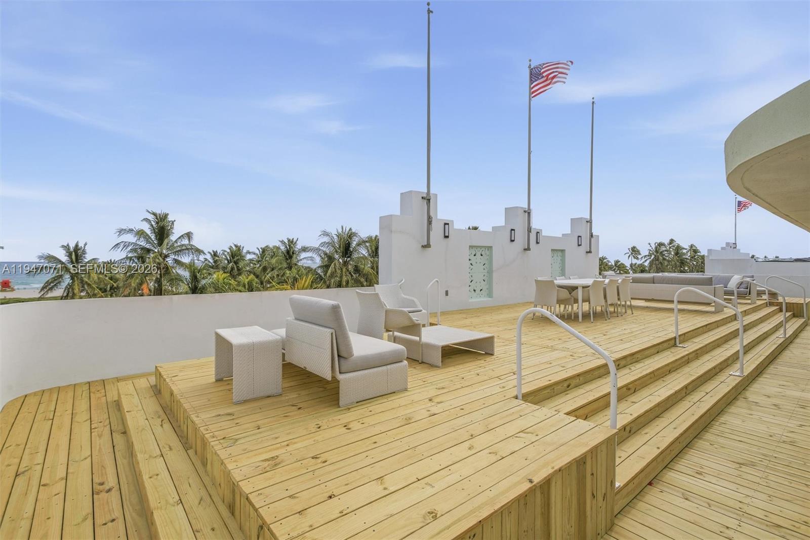 A wooden deck features outdoor seating and dining furniture with a view of palm trees — 1250 Ocean Dr, Miami Beach FL 33139, MIAMI BEACH, FL