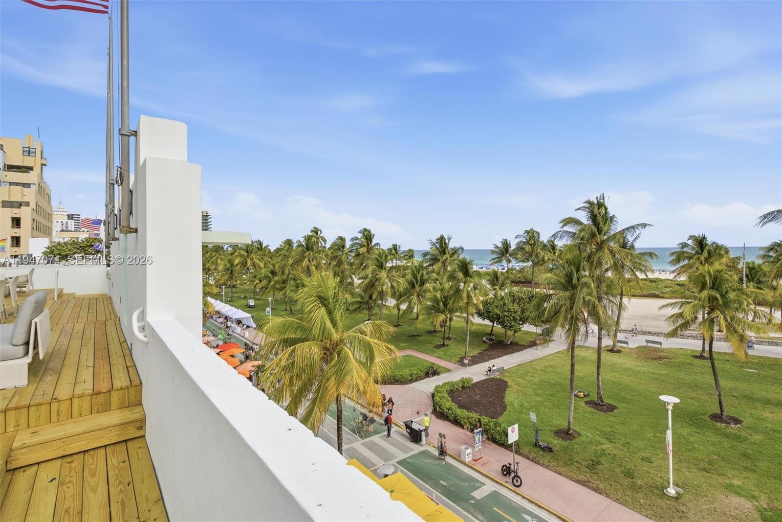 An elevated balcony view overlooks a park with palm trees, a bike path, and the ocean — 1250 Ocean Dr, Miami Beach FL 33139, MIAMI BEACH, FL